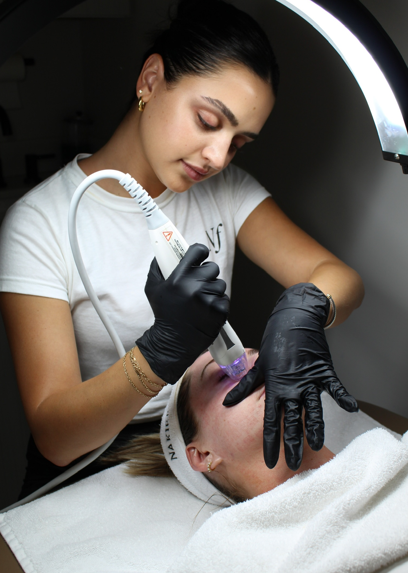 Nakie Face aesthetician performing a facial treatment